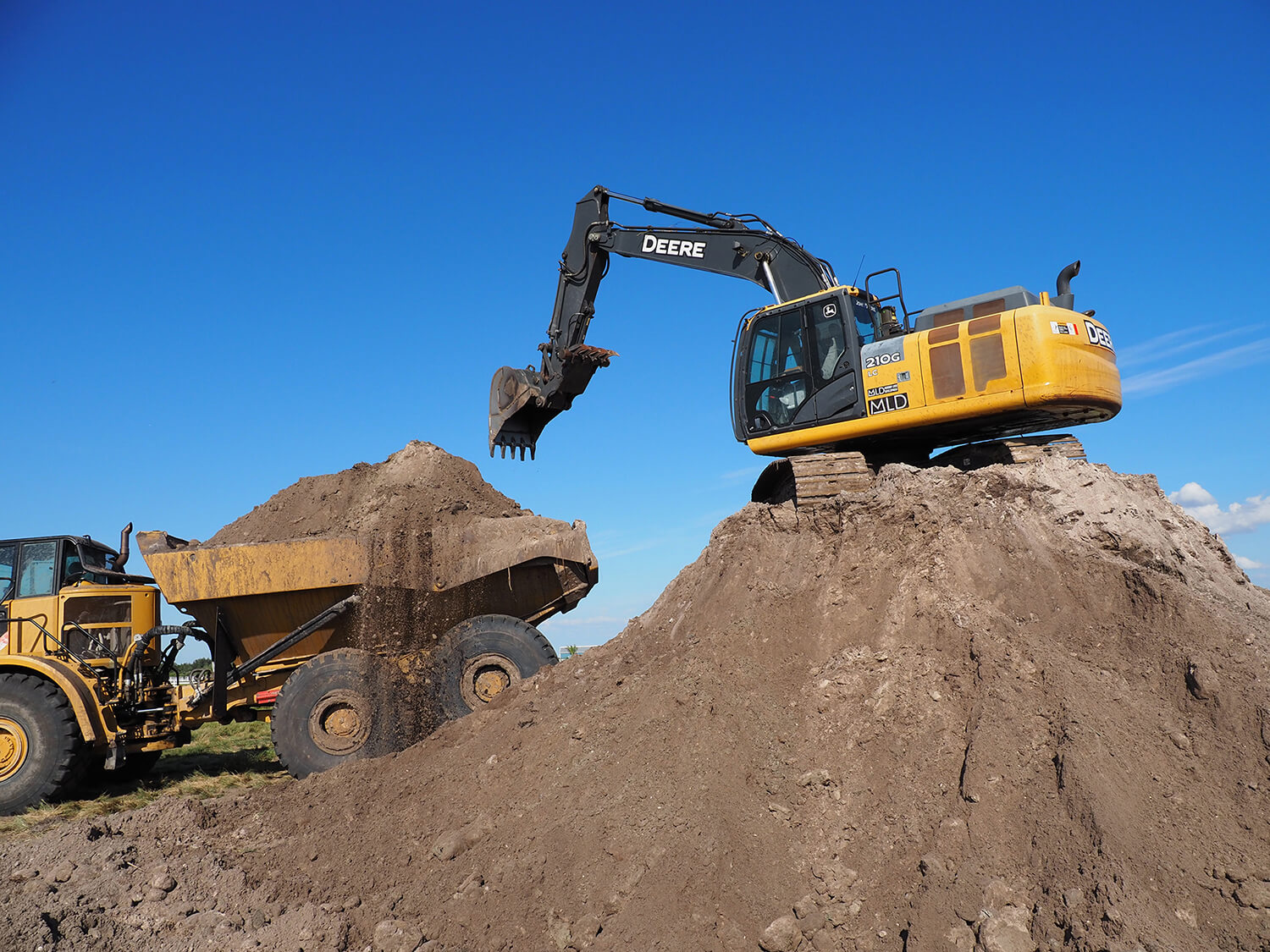 Murray Land Development excavator dumping dirt into a dump truck